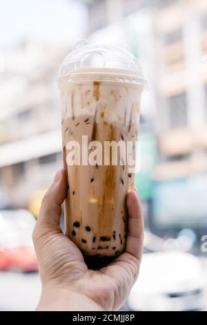 Bubble Ball Eis Milch Tee in der Hand mit Blur Asia Gebäude Hintergrund. Stockfoto