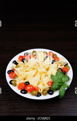 Pasta mit Olivenöl, Knoblauch, Basilikum und Tomaten und gewürzt mit Parmesan. Stockfoto