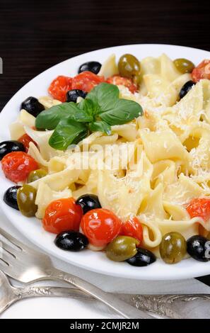 Pasta mit Olivenöl, Knoblauch, Basilikum und Tomaten und gewürzt mit Parmesan. Stockfoto