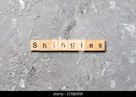 Schindeln Wort auf Holzblock geschrieben. Schindeln Text auf Zementtisch für Ihr Design, Konzept. Stockfoto