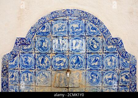 Blaue Fliesen schmücken einen dekorativen Brunnen im Alcazar von Sevilla, Spanien Stockfoto