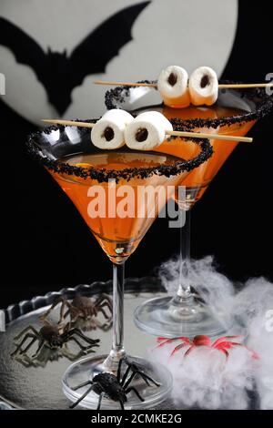 Glas von Zitrus martini mit schwarzem Zucker mit Marshmallow verziert Augen auf dem Tisch zu Ehren von Ha Stockfoto