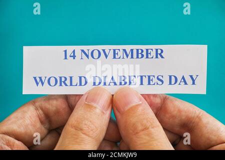 Person, die ein Stück Papier mit den Worten Weltdiabetestag (14. November) hält. Nahaufnahme. Stockfoto