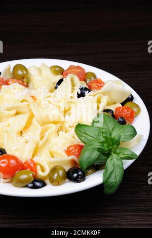 Pasta mit Olivenöl, Knoblauch, Basilikum und Tomaten und gewürzt mit Parmesan. Stockfoto