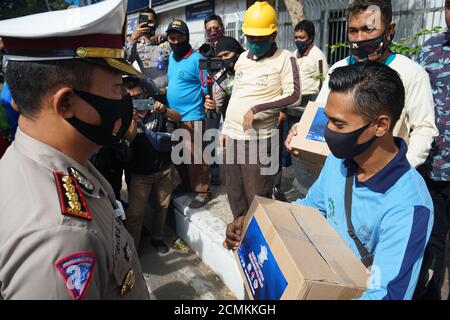 Makassar, Indonesien. September 2020. Angehörige der indonesischen Polizei leisten Unterstützung für von Covid-19 betroffene Einwohner. Diese Hilfe wurde durchgeführt, während die Sozialisierung über die Bedeutung des Tragens von Masken und die Einhaltung der Distanz. (Foto: Herwin Bahar/Pacific Press/Sipa USA) Quelle: SIPA USA/Alamy Live News Stockfoto