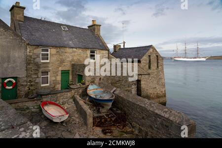 Lerwick, Schottland, Großbritannien. September 2020, 17. Die Statsraad Lehmkuhl, ein dreimastigen Hochschiff, das für das Training verwendet wird, verlässt den Hafen von Lerwick und fährt nach Bergen in Norwegen. Im Vordergrund befindet sich das berühmte alte Lodberrie, ehemaliges Lagerhaus und Handelsdock. Iain Masterton/Alamy Live News Stockfoto