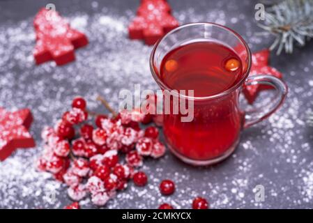 Tee aus frischen roten Viburnum in einem durchsichtigen Glas auf schwarzem Hintergrund Stockfoto