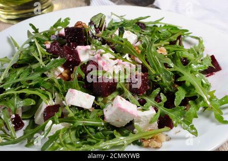 Salat aus gerösteten Rüben, Rucola, Käse Feta und Walnüssen. Horizontalen Schuss. Vordergrund Nahaufnahme. Stockfoto