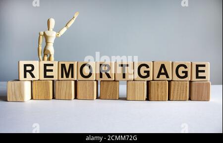 'Remorgage' auf Holzklötzen geschrieben. Geschäftskonzept. Holzmodell des Menschen. Speicherplatz kopieren. Schöner weißer Hintergrund. Stockfoto