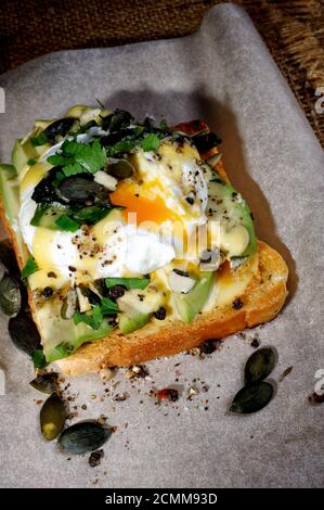 Eier Benedikt auf Toast mit Holländischer Sauce, Scheiben Avocado Stockfoto