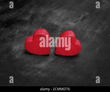 Zwei rote Herzen aus Holz auf einem schwarzen Hintergrund Stockfoto