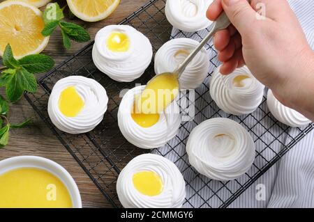 Füllung mit einer Zitrone kurd, eine zarte, knusprige Mini-Dessert Pavlova auf dem Rack Stockfoto