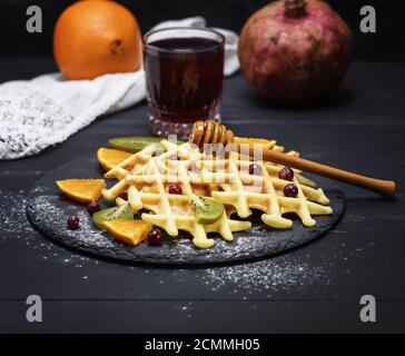 Gebackene belgische Waffeln und ein Glas Granatapfelsaft Stockfoto
