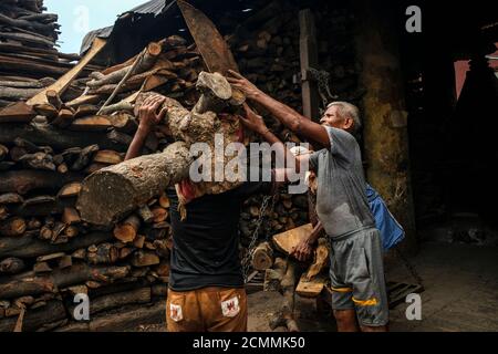 Varanasi, Indien - 2020. September: Männer, die am 13. September 2020 in Uttar Pradesh Feuerholz für Brandungen im Manikarnika Ghat in Varanasi tragen. Stockfoto