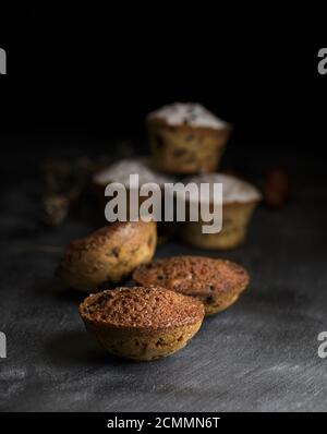 Gebackene Muffins auf einem schwarzen Holztisch Stockfoto