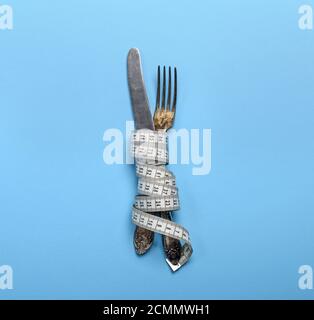 Bügeleisen Messer und Gabel gewickelt in einem Maßband Stockfoto
