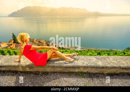 Tour Weinprobe mit Panoramalandschaft bei Sonnenuntergang in Lavaux Weinberg Terrassen und Genfersee oder See Leman. Lifestyle blonde Tourist Frau auf Stockfoto