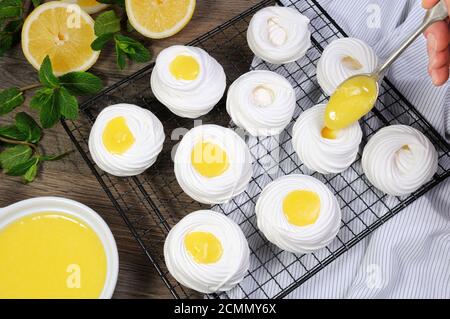 Füllung mit einer Zitrone kurd, eine zarte, knusprige Mini-Dessert Pavlova auf dem Rack Stockfoto