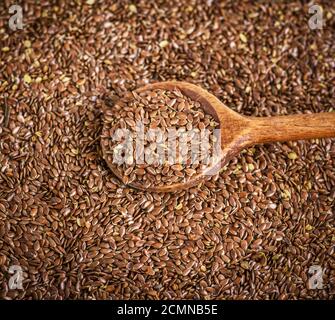 Leinsamen in einem Löffel aus Holz auf einem Stapel Stockfoto