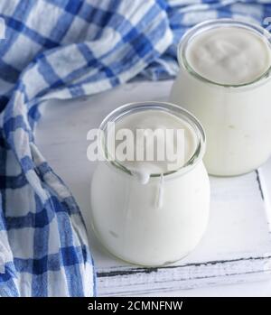 Gläser mit hausgemachtem Joghurt auf ein weißes Holzbrett Stockfoto