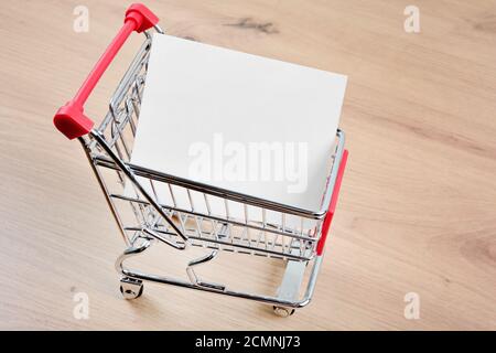 Leeres Papier in einem Warenkorb auf einem Holztisch Stockfoto