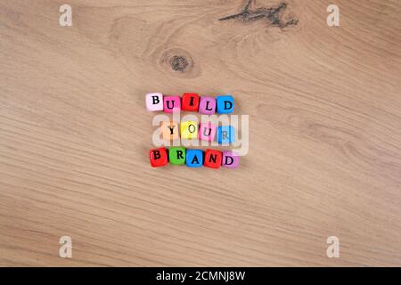 Bauen Sie Ihre Markenwörter und auf einem Holztisch Stockfoto