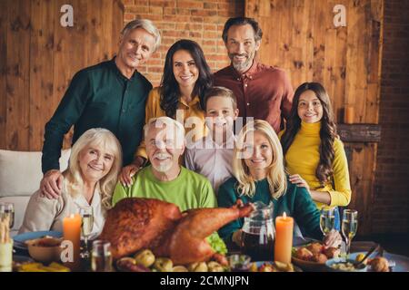 Porträt der ganzen Familie Acht Mitglieder Dank geben Sitzung sitzen Tisch Begrüßung Abendessen Fotografieren Wohnzimmer drinnen Stockfoto