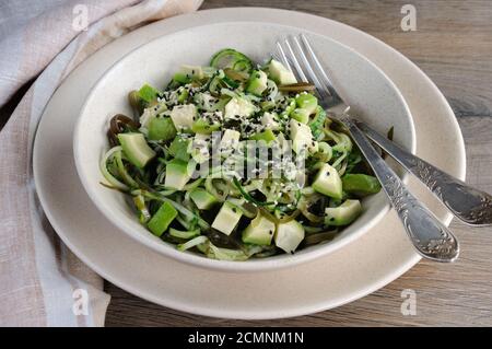 Von Nudeln Salat aus Gurken und laminaria, Scheiben Avocado mit Sesam Stockfoto