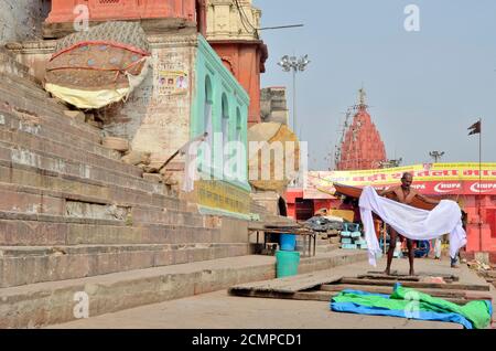 Dies ist ein Bild von Varanasis Ahlyabai Ghat. Ein Pilger trägt neue Kleidung, nachdem er im Ganges am Ahalyabai Ghat gebadet hat. Stockfoto