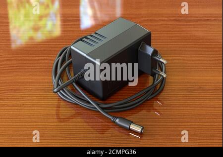 AC DC-Adapter auf dem Holztisch. 3D-Rendering Stockfoto