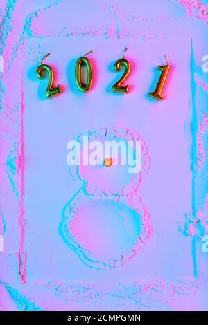 Neujahrskonzept, ein Schneemann aus Mehl mit einem Karotten Nom und Hände passt, in Neonlicht. Stockfoto