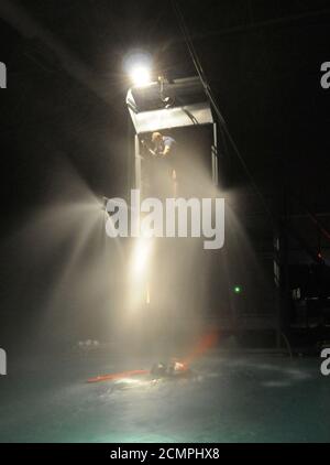 Navy Diver 1. Klasse ein Instruktor am Aviation Survival Training Kurs, senkt einen Hebezeug zu einem Schüler. Stockfoto