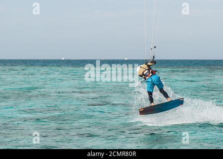 Professionelle Kiter macht das schwieriger Trick auf einem schönen Hintergrund von Sprühen und ocean Oberfläche Stockfoto