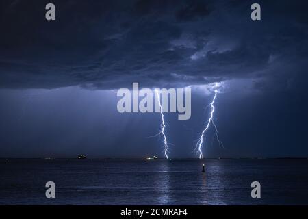 Sturmwolke mit doppeltem Blitzschlag im Wasser Ein Fluss Stockfoto