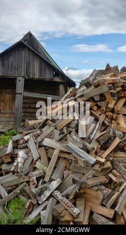 Holzheizung in Dorfhäusern und Bädern in Russland. Badehaus. Im Vordergrund ist Holzstapel aus Birkenholz (Birke gilt als High-ene Stockfoto