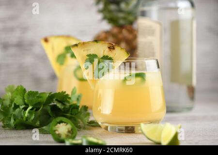 Tequila Cocktail mit Ananassaft, jalapeno Scheiben und cilantro, gekühlt mit Eis Stockfoto