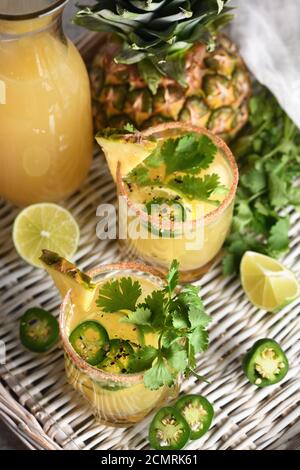 Würzige Ananas Margarita mit Jalapeno Scheiben, Limone und Koriander Zweige Stockfoto