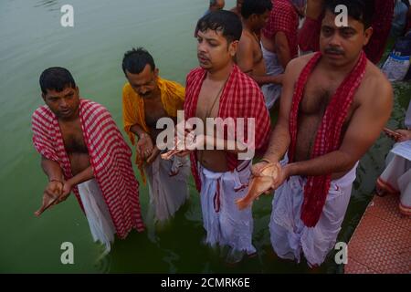 Indische hinduistische Anhänger führen Tarpan, ein Ritual, um den Vorvätern am letzten Tag für das Anbieten von Gebeten an Vorfahren genannt Pitri Tarpan zu gehorchen. In der hinduistischen Mythologie wird dieser Tag auch 'Mahalaya' genannt und als der Tag beschrieben, an dem die Götter die zehn bewaffnete Göttin Durga schufen, um den Dämonenkönig Asur zu zerstören, der plante, die Götter aus ihrem Königreich zu vertreiben. Die fünf-Tage-Periode der Anbetung von Durga, wird als der Zerstörer des Bösen zugeschrieben. Agartala, Tripura, Indien. Stockfoto