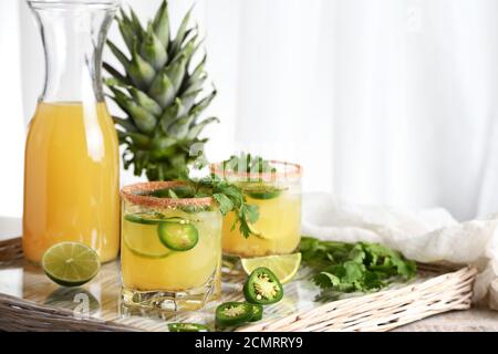 Würzige Ananas Margarita mit Jalapeno Scheiben, Limone und Koriander Zweige Stockfoto