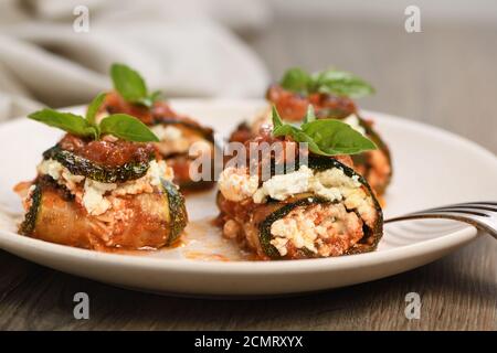 Gebackene Zucchini Brötchen gefüllt mit Ricotta und Basilikum unter Tomaten - Zwiebel - Sauce Stockfoto