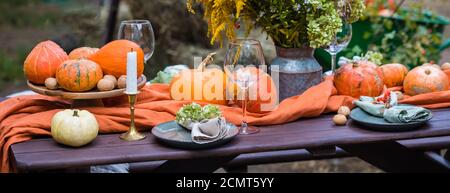 Herbst themed Urlaub Tisch Einstellung Arrangement für eine saisonale Party, Gläser, Kürbisse, Kerzen, Feldblumen Stockfoto