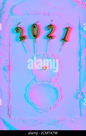 Neujahrskonzept, ein Schneemann aus Mehl mit einem Karotten Nom und Hände passt, in Neonlicht. Stockfoto