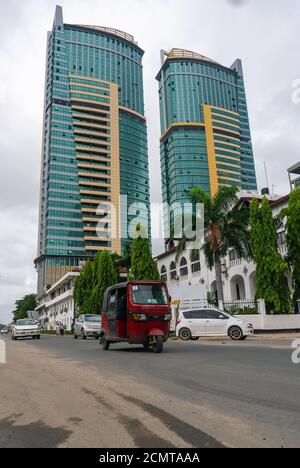 Dar Es Salaam, Tansania - Januar 2020: Hohe moderne Gebäude und eine Straße mit Tuk-Tuk in dar es Salaam, Tansania Stockfoto