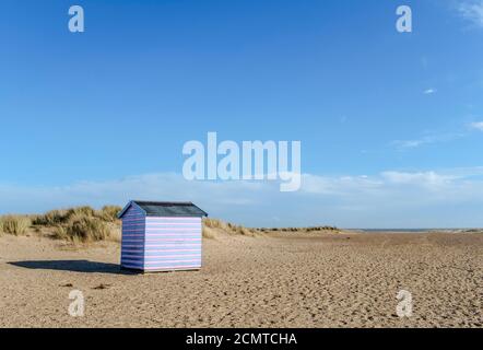 Eine einzelne Beach Hut allein stehend auf einem Sandstrand. Stockfoto