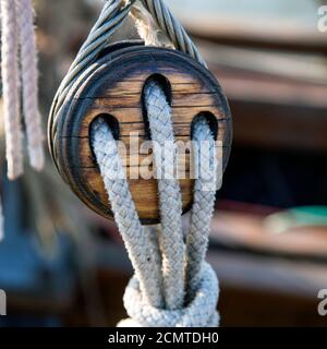 Alte hölzerne Riemenscheibe mit Seilen auf einem Segelschiff Stockfoto