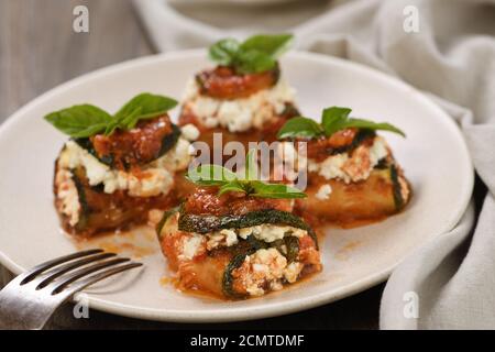 Gebackene Zucchini Brötchen gefüllt mit Ricotta und Basilikum unter Tomaten - Zwiebel - Sauce Stockfoto