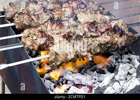 Fleischstücke auf einem Spieß über Holzkohle gebraten Stockfoto