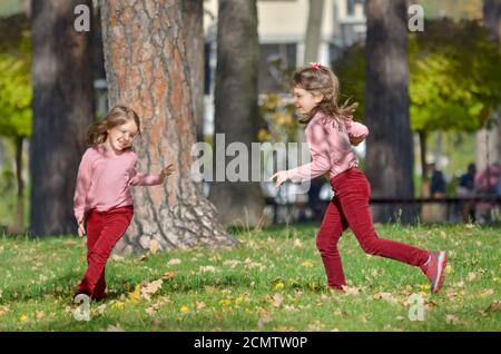 Zwei kleine Schwestern haben Spaß im Freien im Park an einem warmen Herbsttag. Das Konzept einer glücklichen, unbeschwerten Kindheit. Stockfoto