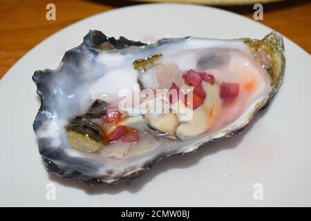 Ein halbes Dutzend Austern mit Zitrone und Schalotte Rotwein Essig. Nach der Ernte aus Whitstable Bay gefischt, werden sie in natürlichem Meerwasser gereinigt. Stockfoto