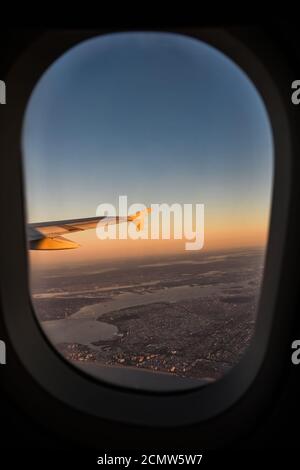 Ein Flugzeugflügel vom Fenster aus gesehen und New York City in der Ferne gesehen. New York aus der Perspektive eines Flugzeugs. Stockfoto